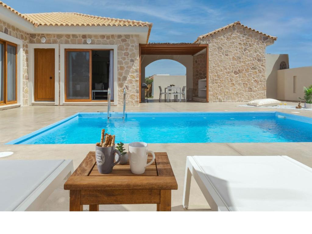 a villa with a swimming pool and a house at Villa Aqua - Laganas Stone Villas in Laganas