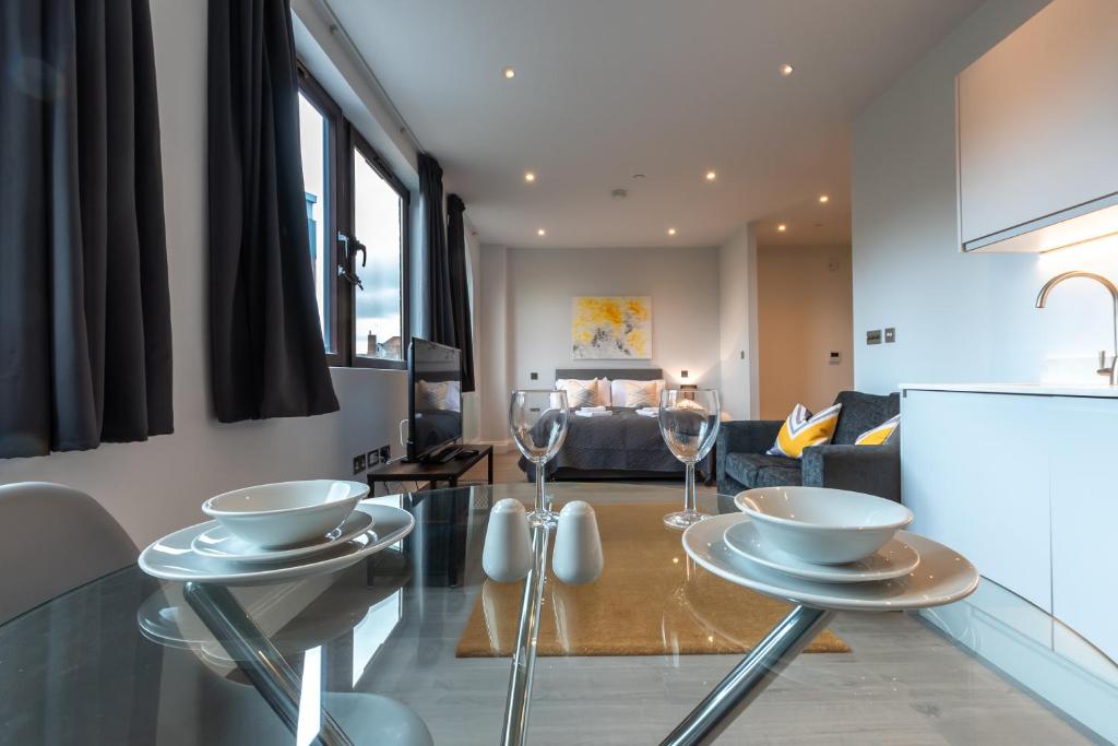 cocina y sala de estar con mesa y copas de vino en Apartment Nine Staines Upon Thames - Free Parking - Heathrow - Thorpe Park, en Staines