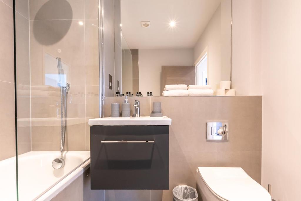 een badkamer met een wastafel, een toilet en een douche bij Apartment Six Staines Upon Thames - Free Parking - Heathrow - Thorpe Park in Staines