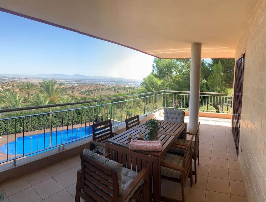 a balcony with a table and chairs and a swimming pool at Villa Gloria in Los López