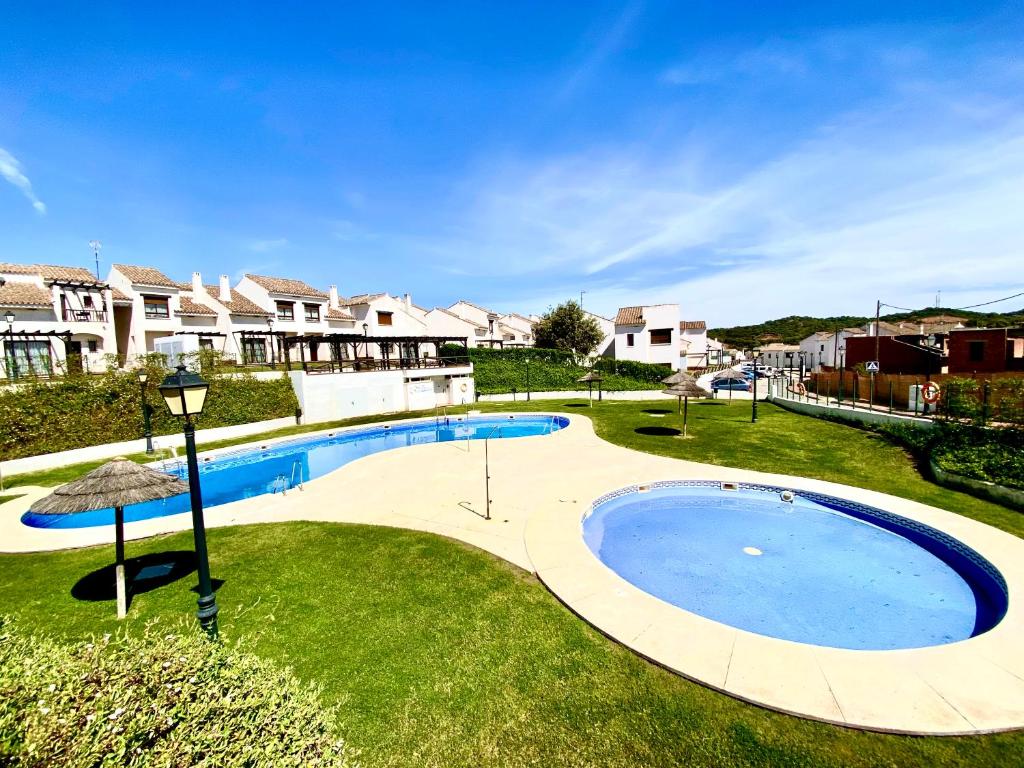 a large swimming pool in a yard with houses at Casita rural Sierra de Sevilla, combina una maravilla in Seville