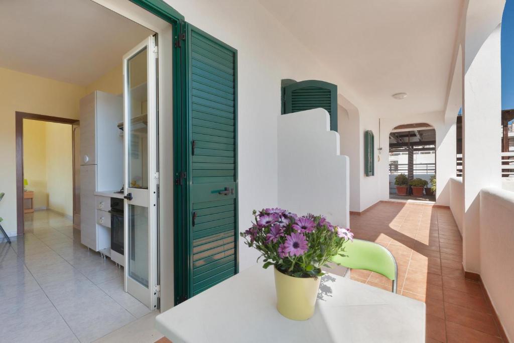 a room with a green door and flowers on a table at Dima Apartments by BarbarHouse in San Foca