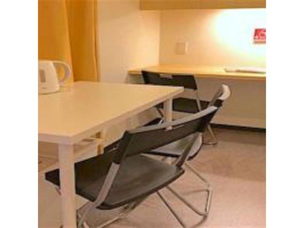 una mesa blanca y 2 sillas en una habitación en 3-25-2 Higashiogu - Apartment / Vacation STAY 8340, en Tokio
