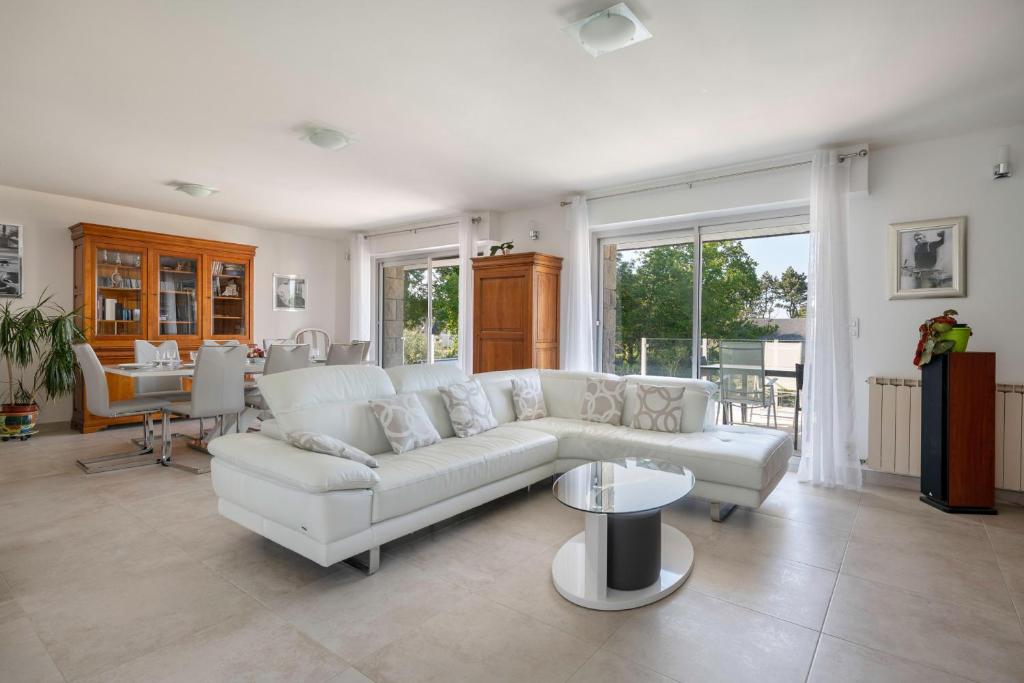 a living room with a white couch and a table at Deconnexion et detente sur la Presqu ile de Rhuys in Le Tour-du-Parc