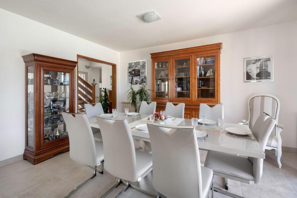 a dining room with a white table and white chairs at Deconnexion et detente sur la Presqu ile de Rhuys in Le Tour-du-Parc