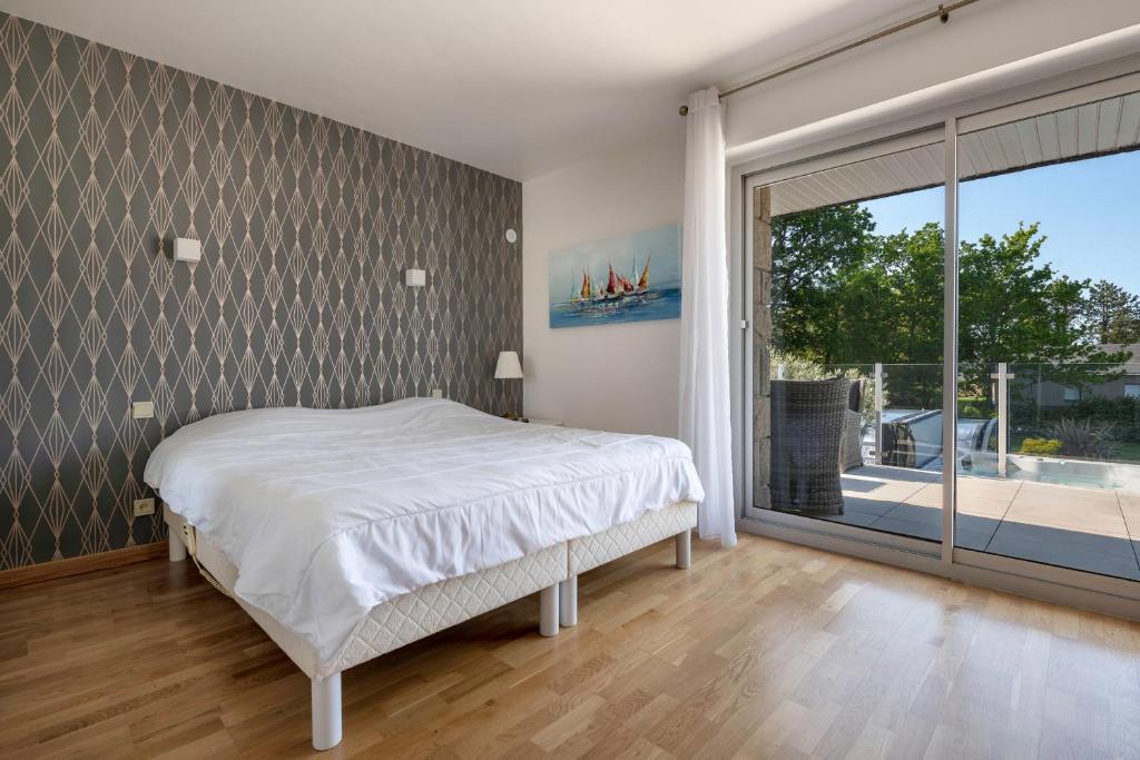 a bedroom with a bed and a large window at Deconnexion et detente sur la Presqu ile de Rhuys in Le Tour-du-Parc