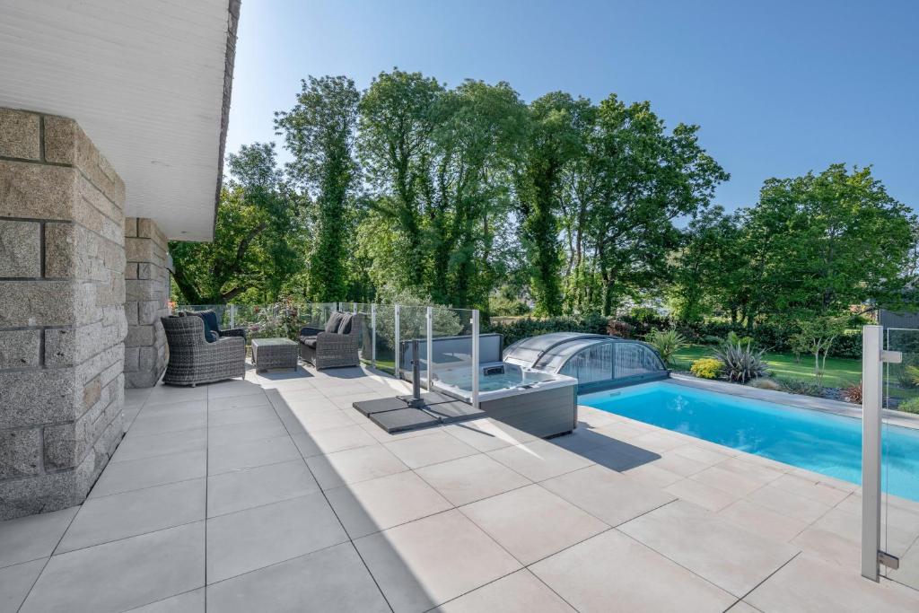 a backyard with a swimming pool and a patio with chairs at Deconnexion et detente sur la Presqu ile de Rhuys in Le Tour-du-Parc