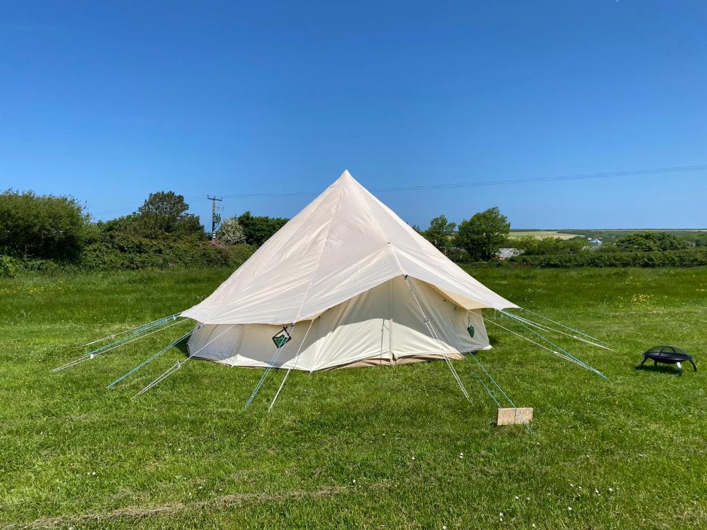 a tent sitting in the grass in a field at Unfurnished Bell Tent close to SWC path in Hartland