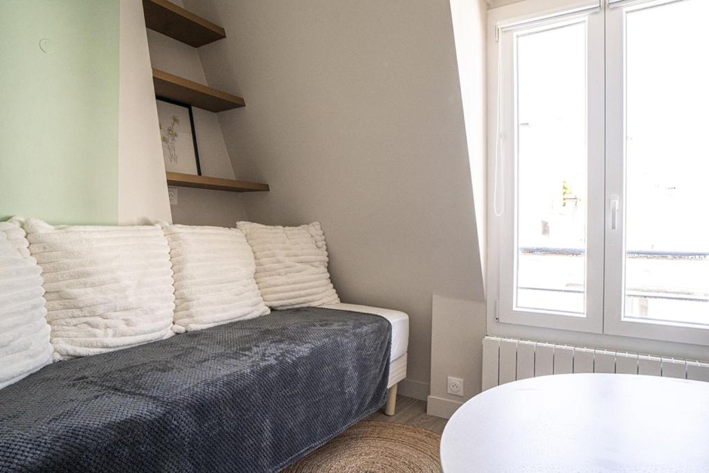 une chambre avec un lit, une table et une fenêtre dans l'établissement Bright 20m near the Eiffel Tower, à Paris