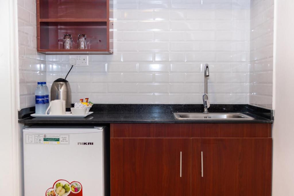 a small kitchen with a sink and a dishwasher at Fujairah Hotel & Resort in Fujairah