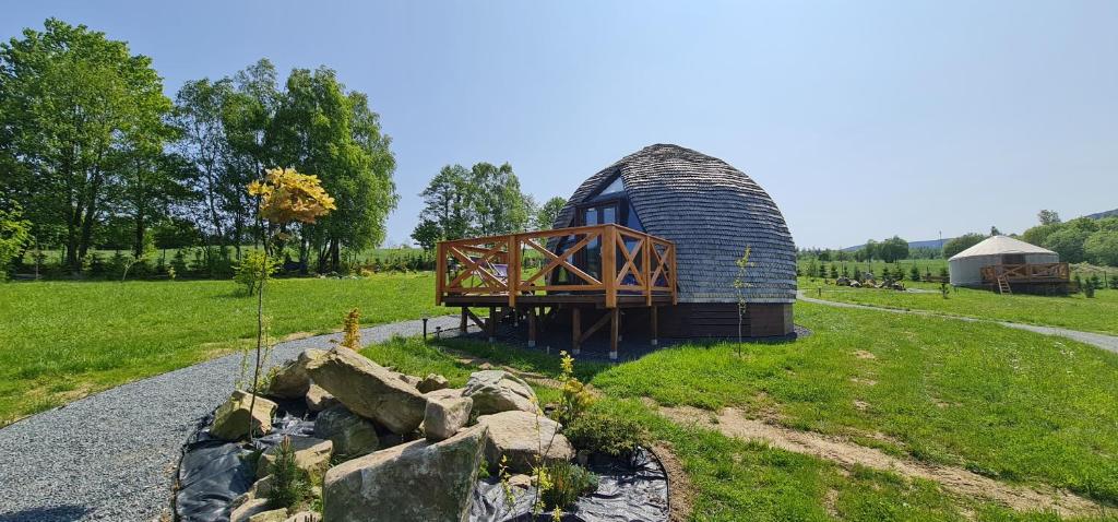 una casa en una cúpula en un campo con un camino de grava en 4 Żywioły - całoroczne domki kopułowe w Sudetach en Stronie Śląskie
