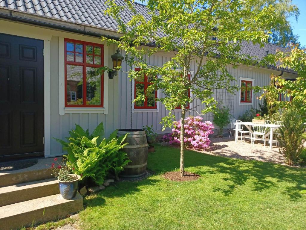 ein kleines Haus mit einem Baum im Hof in der Unterkunft B&B Olsegården in Tvååker