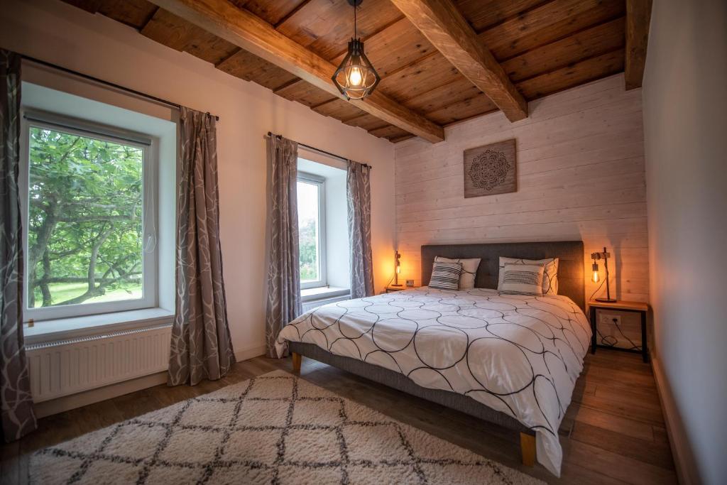 a bedroom with a bed and a large window at Florie Cottage in Cserszegtomaj