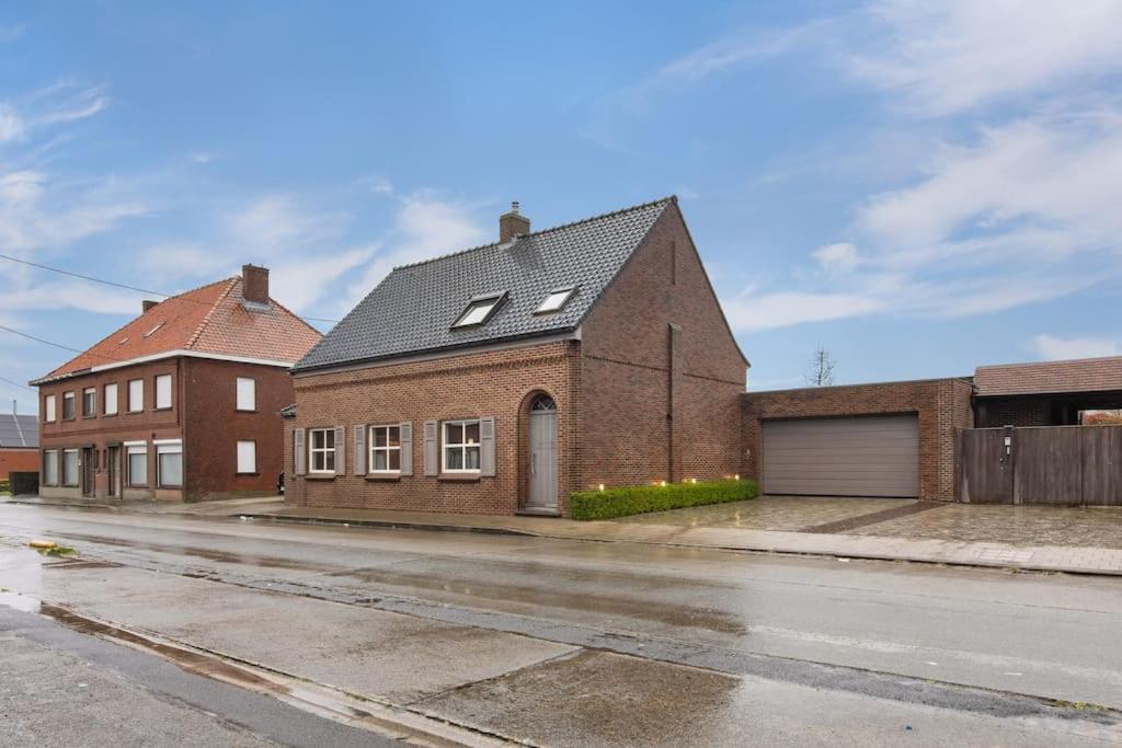 une maison en briques sur le côté d'une rue dans l'établissement Gezellige woning in Oostnieuwkerke, à Staden