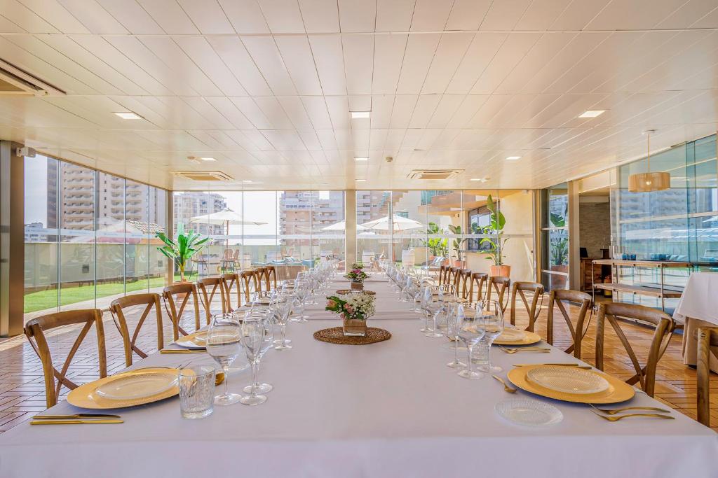 a long table with chairs and plates and glasses on it at Cullera Holiday in Cullera