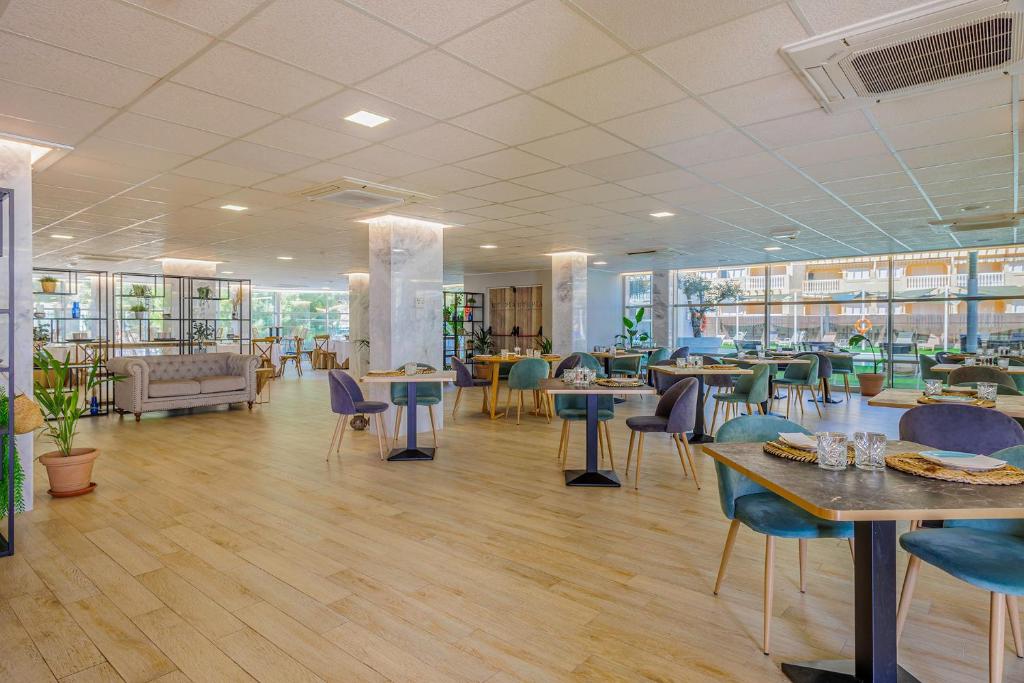 a restaurant with tables and chairs in a room at Cullera Holiday in Cullera