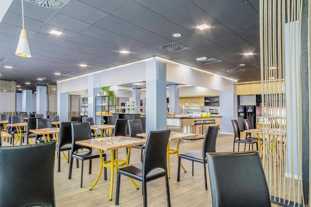 a restaurant with tables and chairs and a kitchen at Cullera Holiday in Cullera