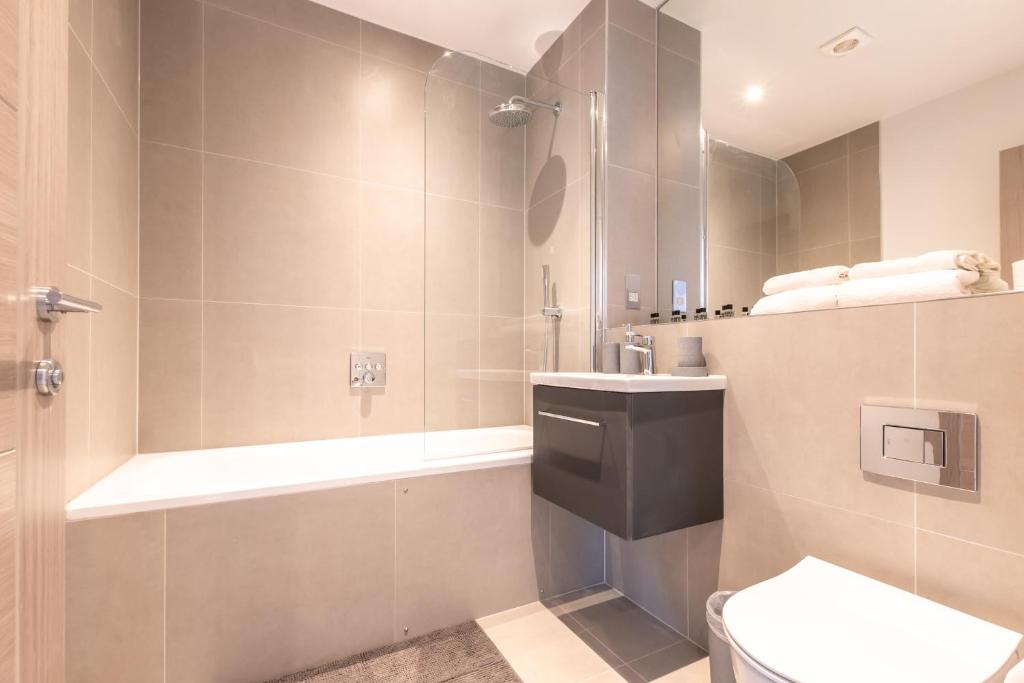 a bathroom with a shower and a toilet and a sink at Apartment Thirty Three Staines Upon Thames - Free Parking - Heathrow - Thorpe Park in Staines