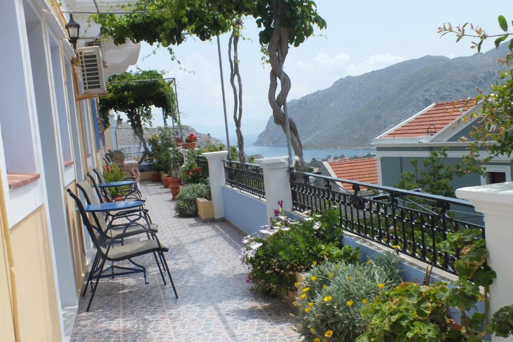 un balcón de una casa con sillas y plantas en Anastasia Apartments (Chorio) en Symi