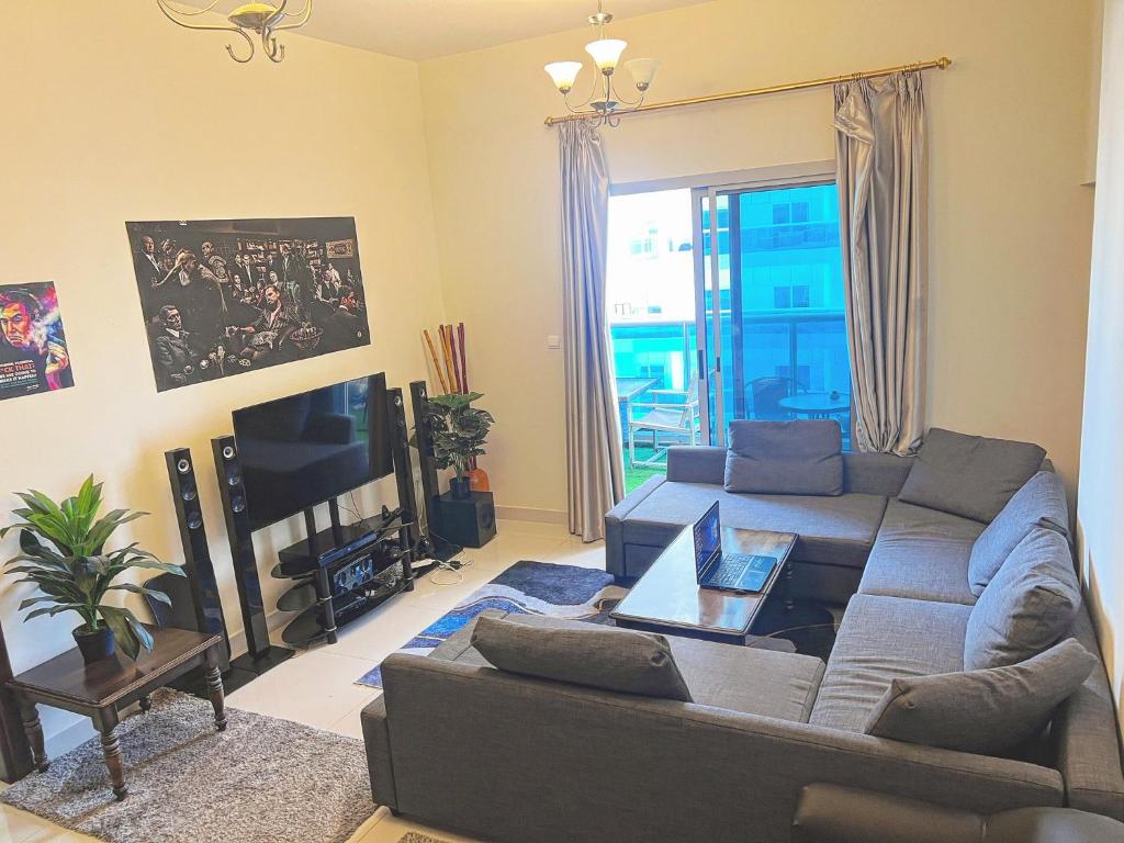 a living room with a couch and a tv at Dubai Sport City in Dubai