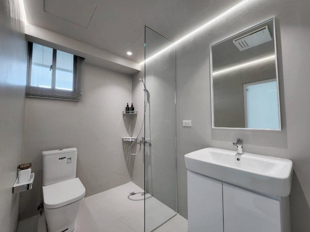 a bathroom with a toilet and a sink and a shower at White window sea in Hengchun