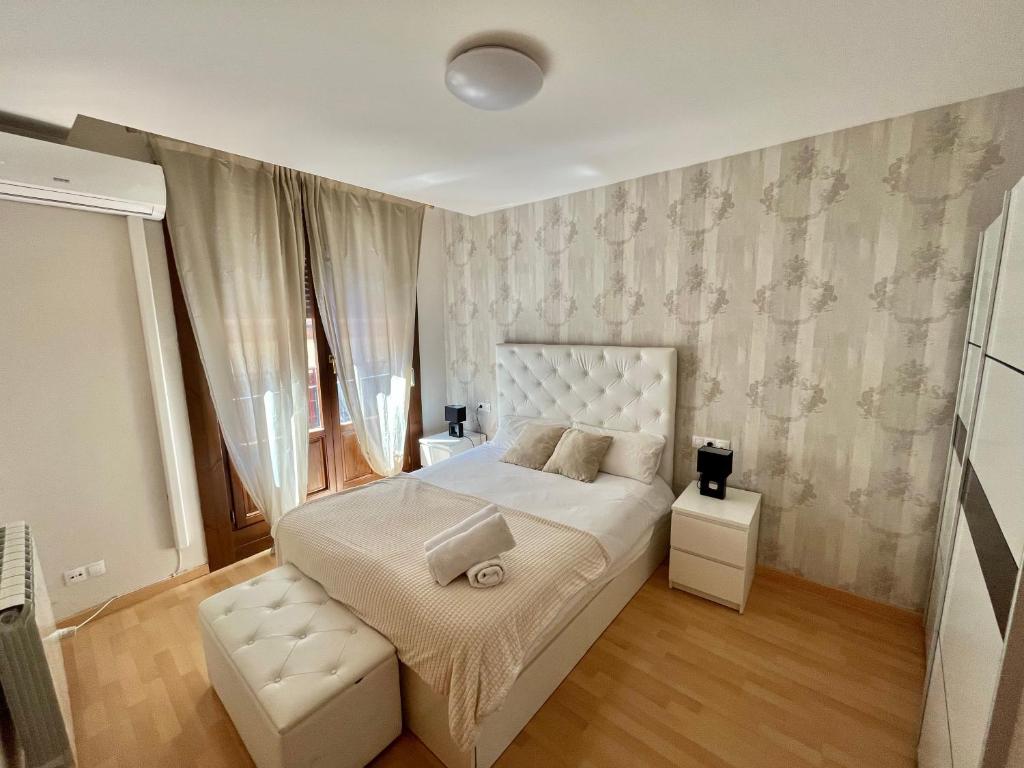 a bedroom with a white bed with a white headboard at Oupen de dor - Boggiero in Zaragoza