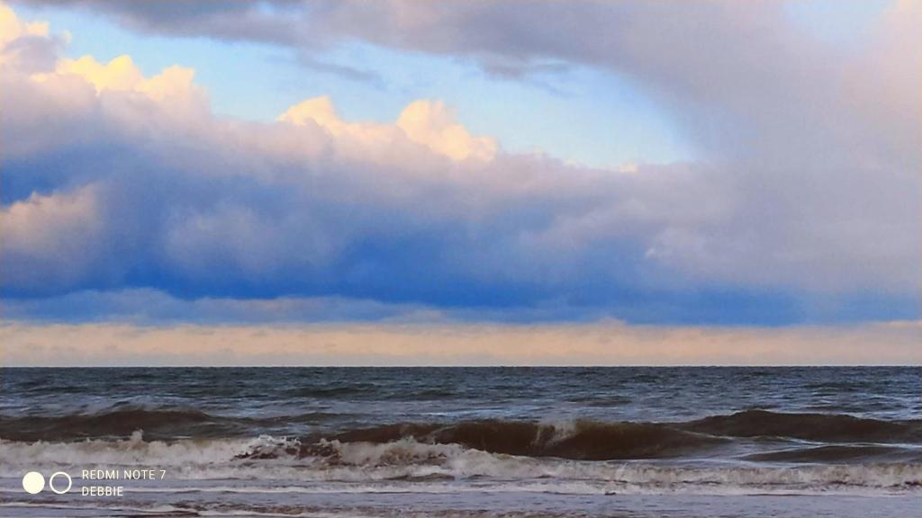 un cielo nublado sobre el océano con olas en LoftBeach, en Koksijde