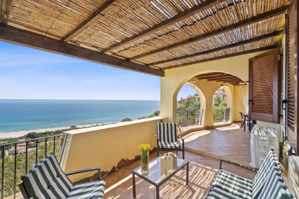 a balcony with chairs and a view of the ocean at Villa Belvedere in Costa Rei