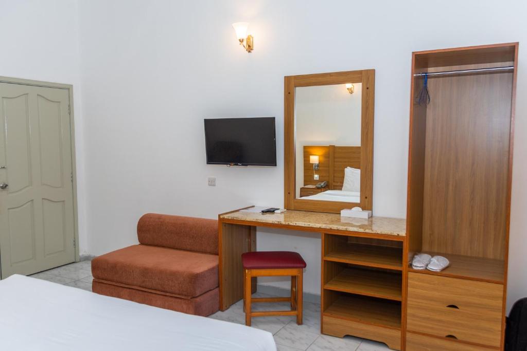 a hotel room with a desk and a mirror at Fujairah Hotel & Resort in Fujairah