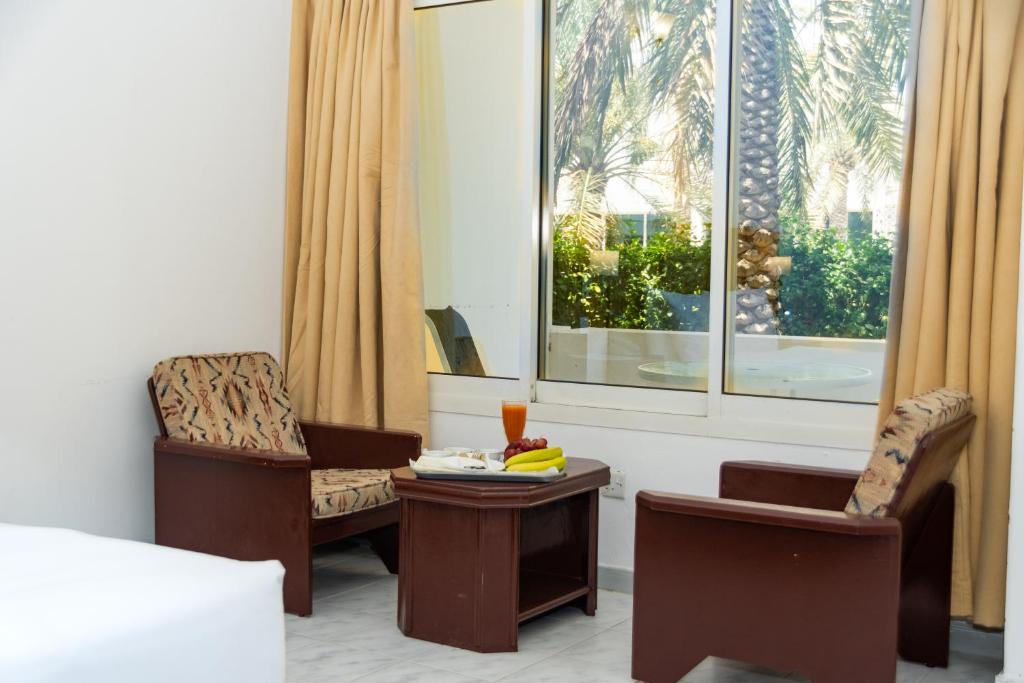 a room with two chairs and a table and a window at Fujairah Hotel & Resort in Fujairah