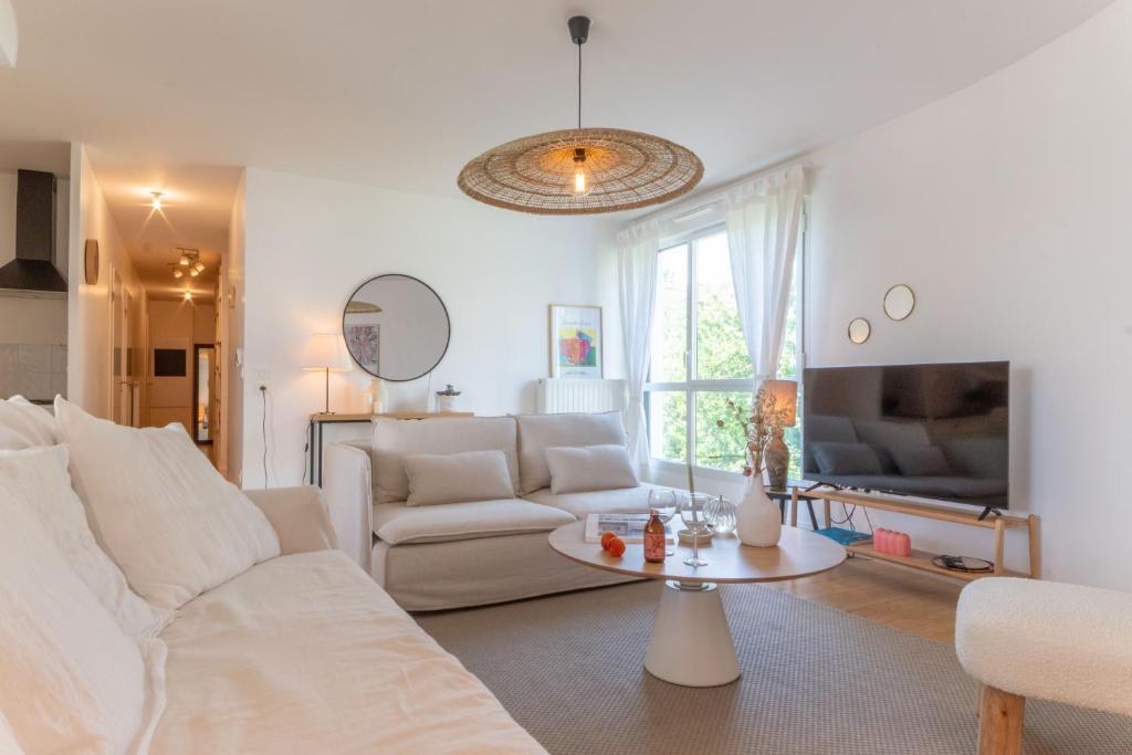 un salon avec un canapé blanc et une table dans l'établissement Bel appartement lumineux à Biarritz, à Biarritz