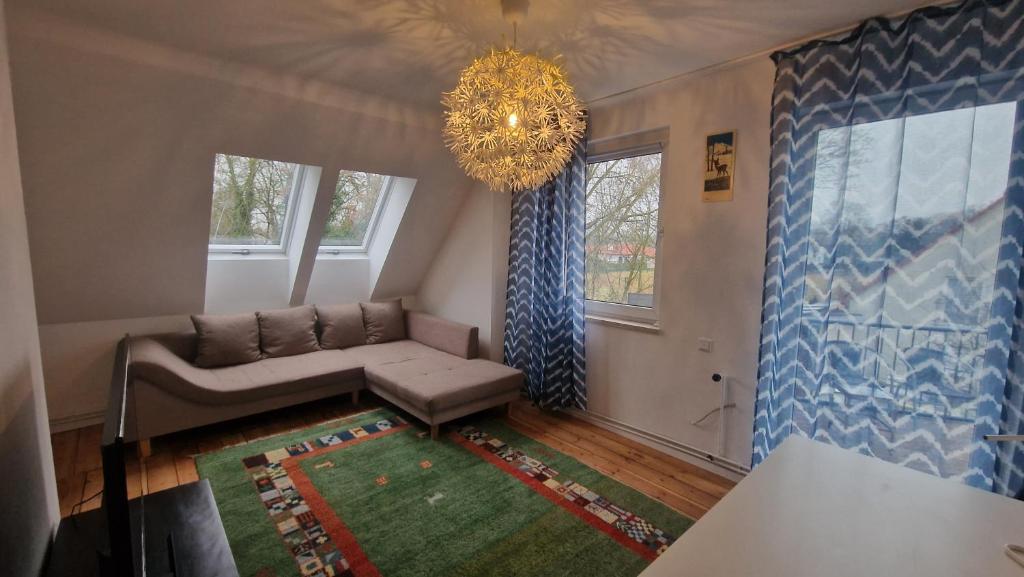 a living room with a couch and a chandelier at Apartment with parking in Berlin 11 in Berlin