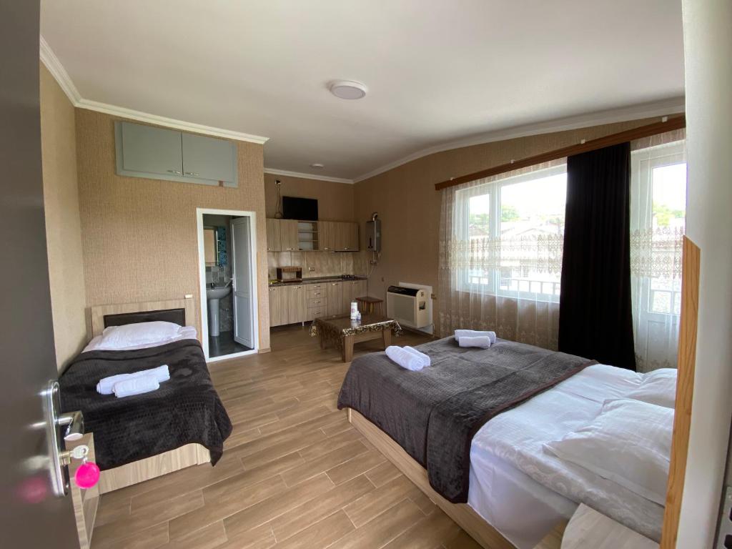 um quarto de hotel com duas camas e uma cozinha em Sweet House Rabati em Akhaltsikhe