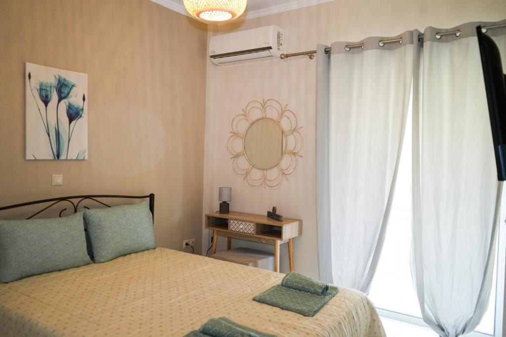 een slaapkamer met een bed, een spiegel en een raam bij Stefanos apartment in Nafplio