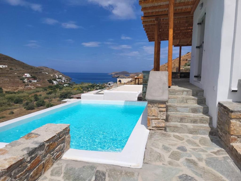 uma piscina com vista para o oceano a partir de uma casa em Epithea Suites Kythnos 3 με ιδιωτική πισίνα em Kythnos