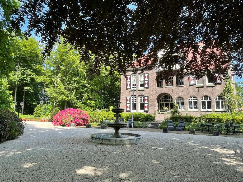 een fontein voor een groot bakstenen gebouw bij Villa Rozenhof in Almen