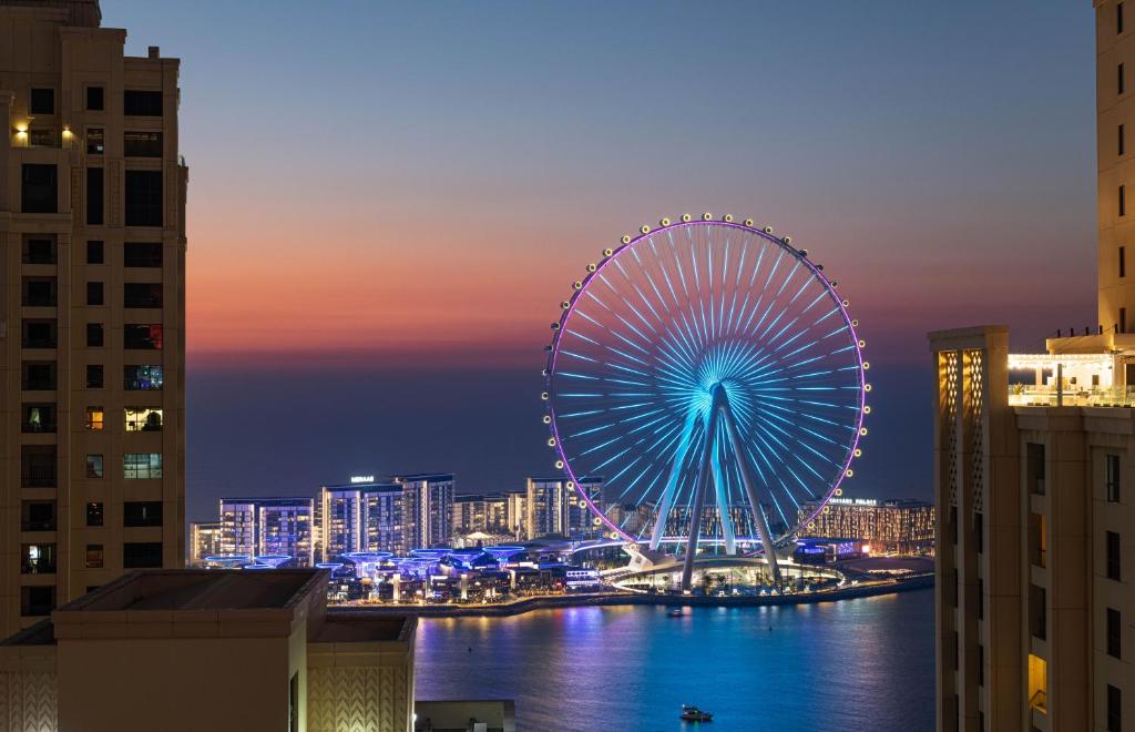 a large ferris wheel in a city at night at Delta Hotels by Marriott Jumeirah Beach, Dubai in Dubai