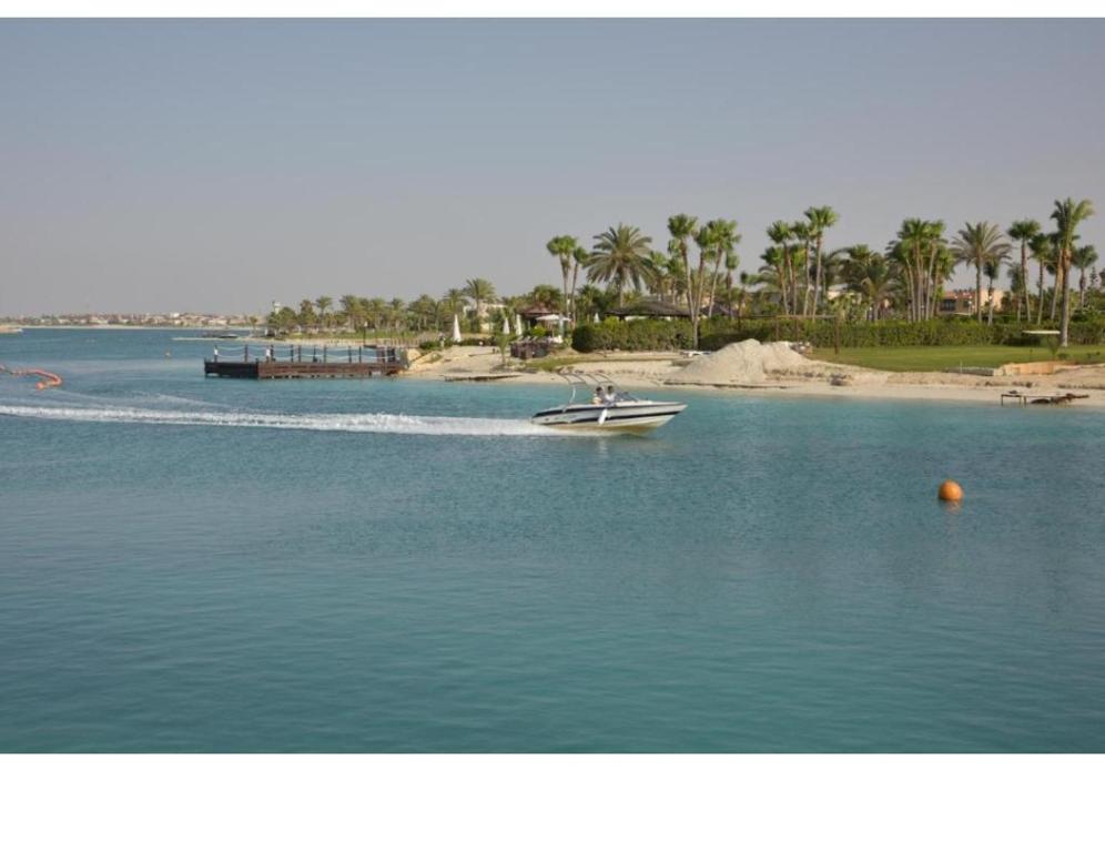 um barco na água ao lado de uma praia em بورتو جولف مارينا فى اي بي شاليه Porto golf marina VIP CHALLET em El Alamein