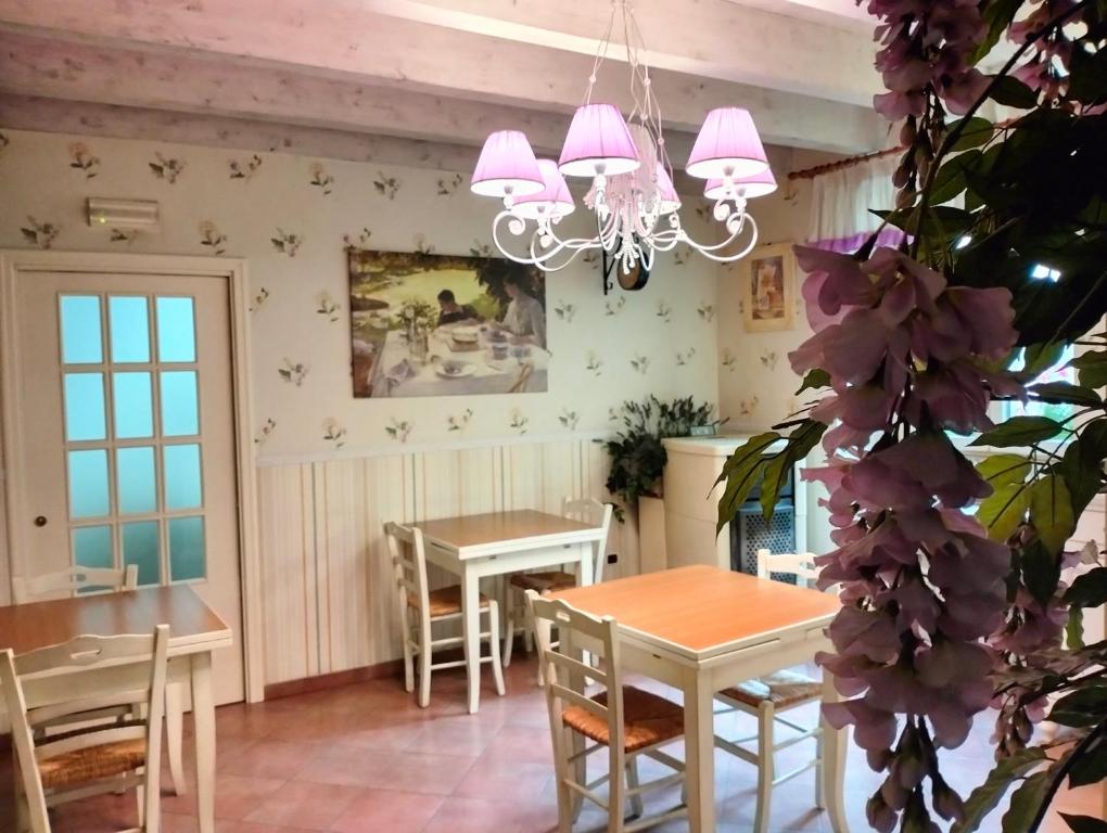 ein Esszimmer mit einem Tisch, Stühlen und einem Kronleuchter in der Unterkunft Bed & Breakfast De Nittis in Barletta