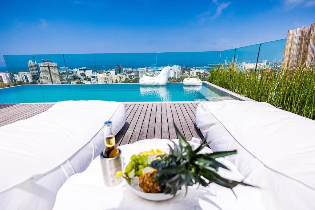 a table with a bowl of food next to a pool at SERENE - Infinity Cview pool - 4 bedrooms Luxury Penthouse in Haifa