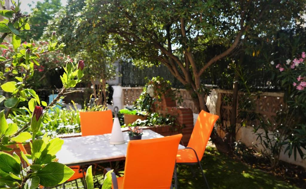 een tafel met oranje stoelen in de tuin bij Chalet Santa Rita in Isla Canela