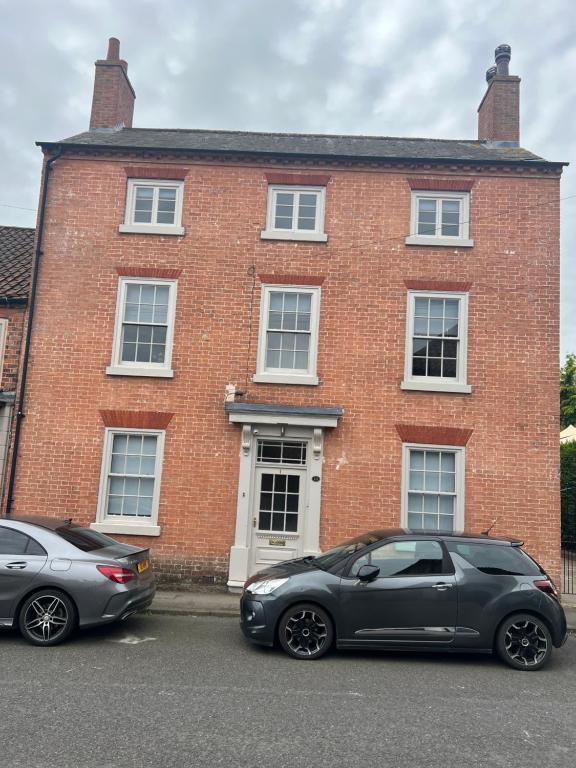 two cars parked in front of a brick building at Swan House - 5 x Executive Apartments - Central Bawtry in Bawtry