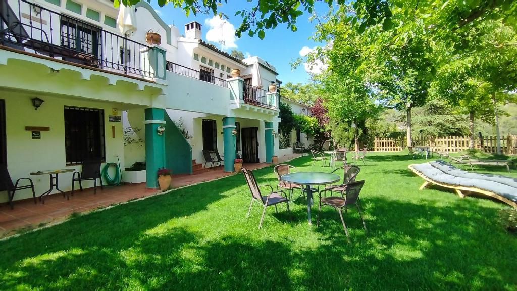 a yard with a table and chairs in front of a building at Alojamiento Rural Las Maravillas in Cañada Catena