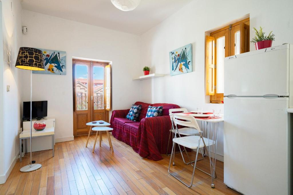 - un salon avec un canapé rouge et une table dans l'établissement My City Home - Luminoso apartamento en Puerta del Ángel, à Madrid