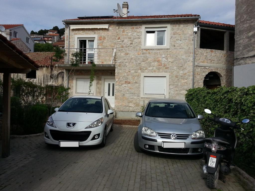 dois carros estão estacionados em frente a uma casa em New Studio Apartments Trlaja em Sibenik