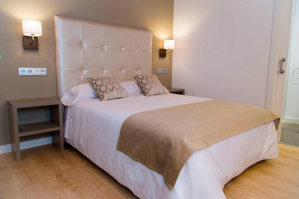 a bedroom with a large bed with a large headboard at Hab Urban Hostel in Segovia