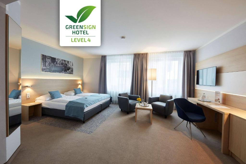 a hotel room with a bed and a desk at GHOTEL hotel & living Göttingen in Göttingen