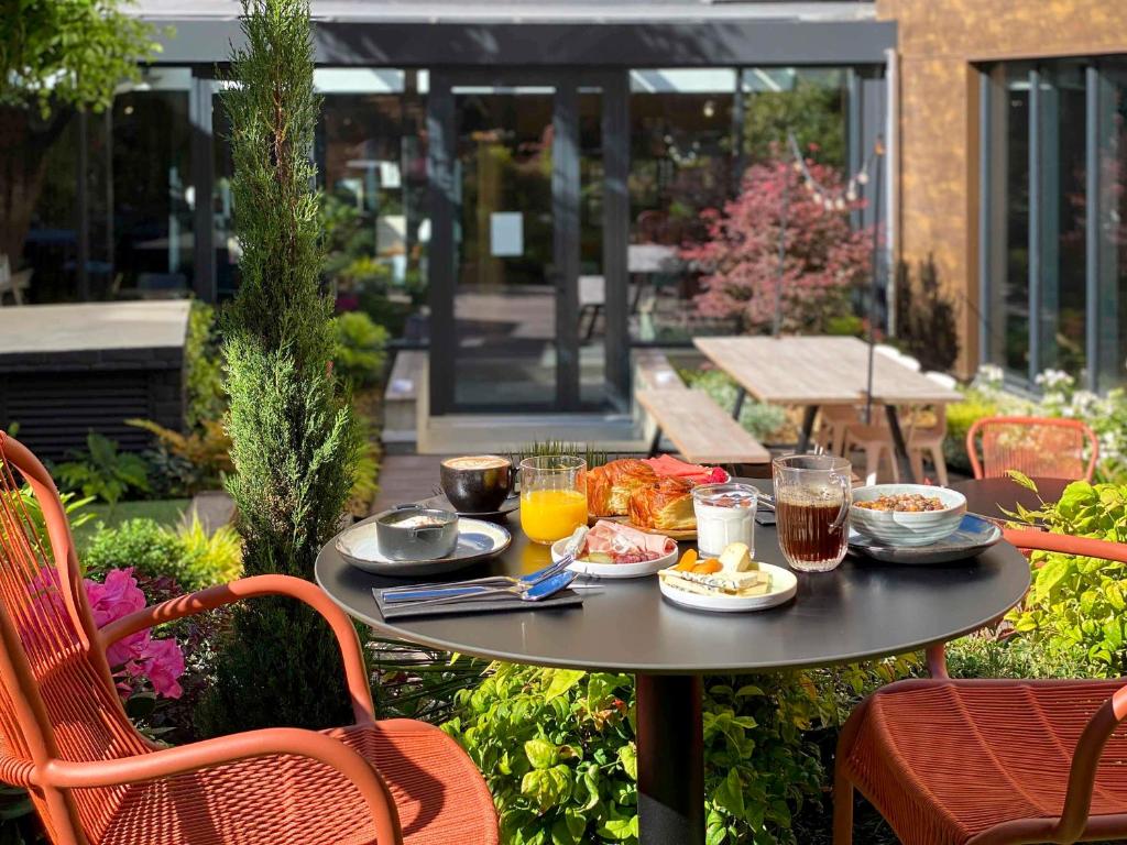 una mesa con comida y bebida en el patio en TRIBE Paris Batignolles, en París