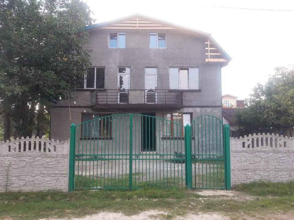 a green fence in front of a house at Ureki გურიის ქუჩა 47ბ in Ureki