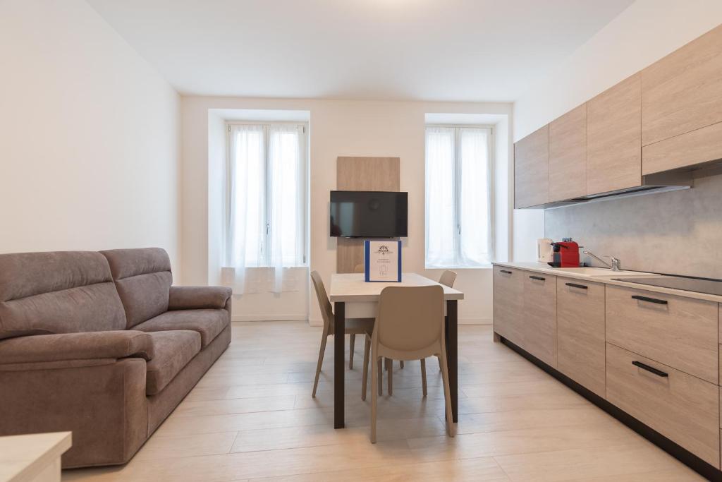 a living room with a couch and a table in a kitchen at Palazzetto La Quadra di San Faustino - F&L Apartment in Brescia